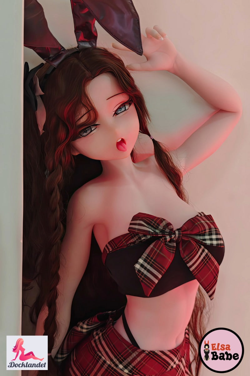 "Elsa Babe 140 cm silikona anime seksa lelle ar lielām bantītes detaļām un melnām zaķa ausīm, kas pozē rūtainā komplektā."