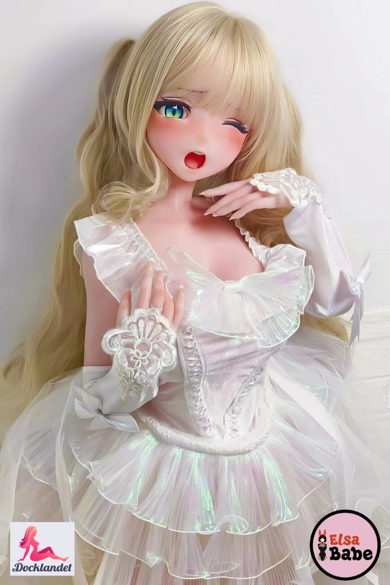 Ichigotani Koi 140 cm silikona seksa lelle no ElsaBabe, guļ uz rozā gultas baltā volānā kleitā, blondi mati un mirgojošas anime acis.